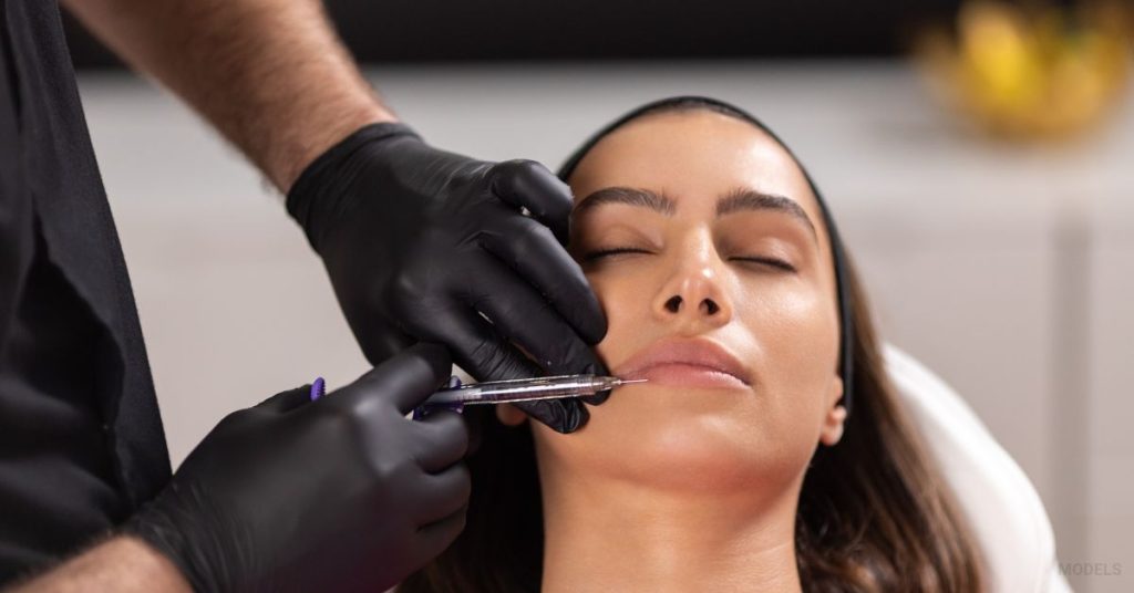 woman getting lip filler injected by doctor (MODELS)